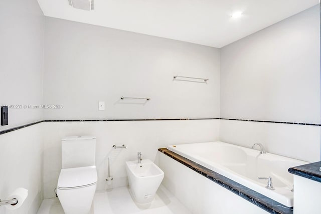 bathroom with a bidet, toilet, and a bathing tub