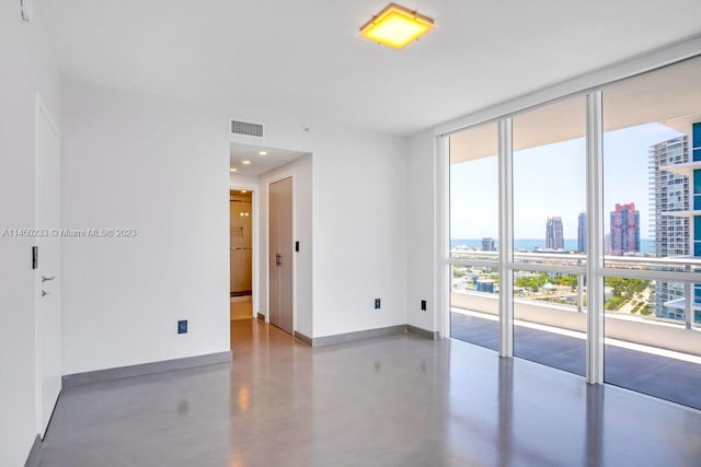 spare room with concrete floors and floor to ceiling windows