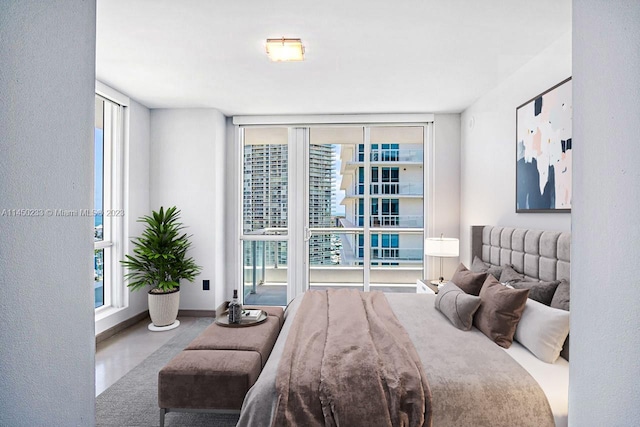 bedroom featuring expansive windows and concrete flooring