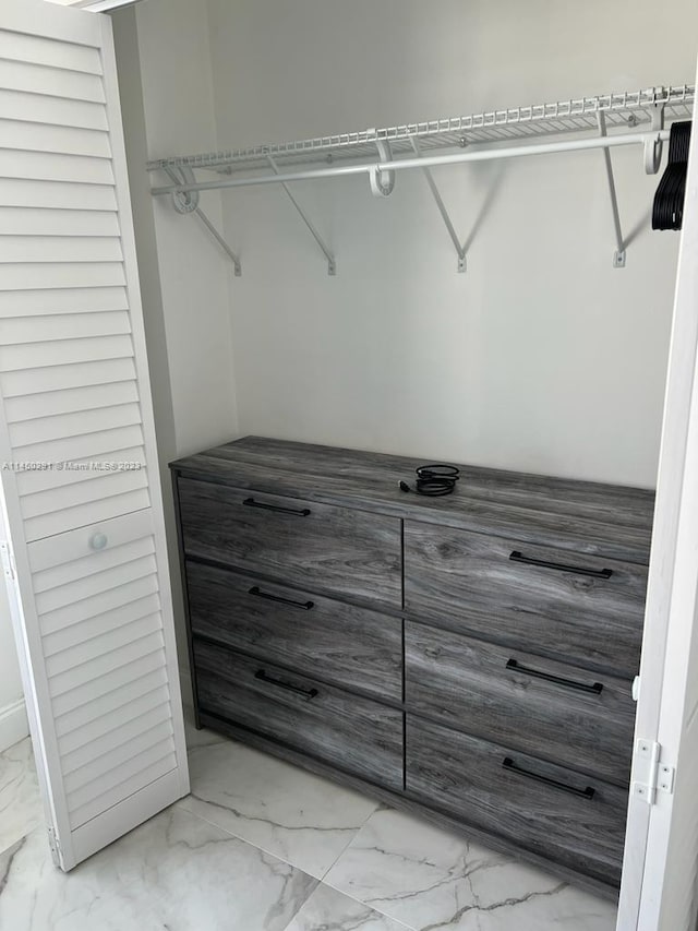 walk in closet with light tile floors