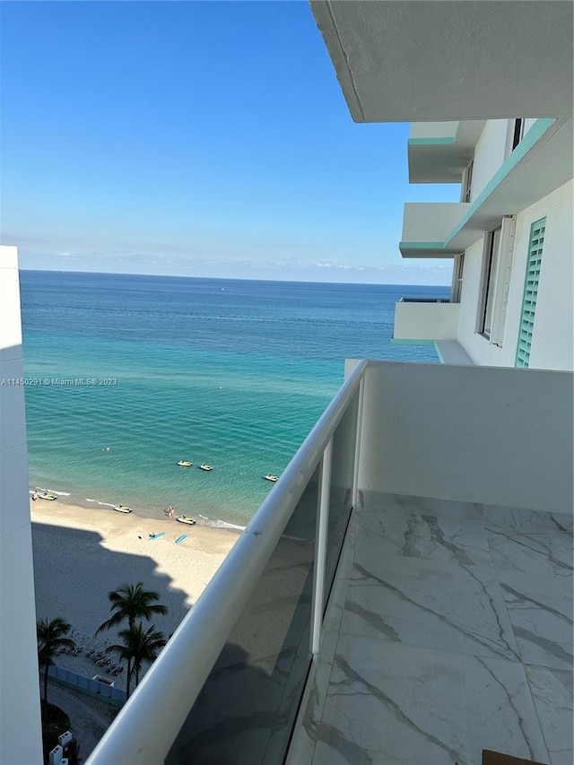 balcony with a water view and a beach view