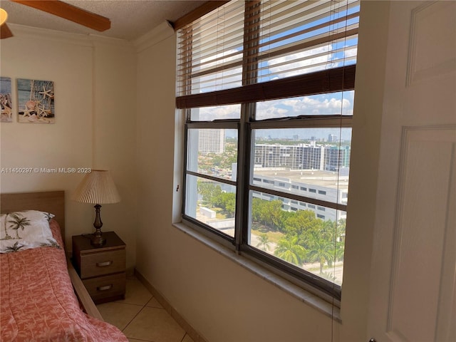 bedroom featuring ceiling fan and light tile floors