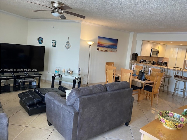 tiled living room featuring ceiling fan, a textured ceiling, and crown molding