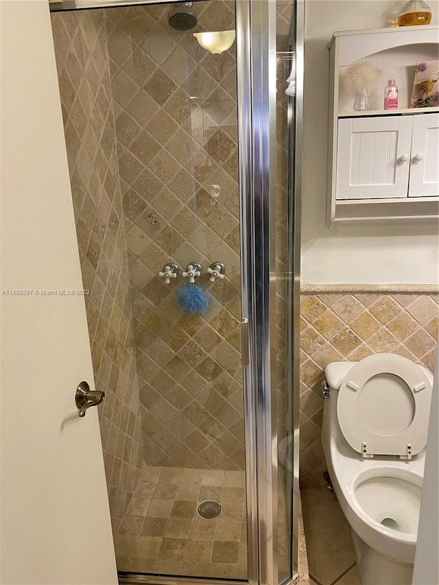 bathroom featuring tile walls, walk in shower, toilet, and tile flooring