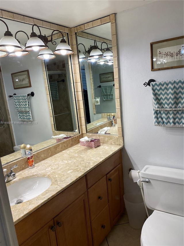 bathroom featuring toilet, vanity with extensive cabinet space, and tile flooring