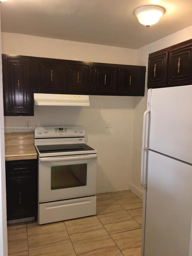 kitchen featuring white appliances, light tile flooring, and dark brown cabinetry