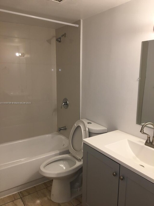 full bathroom featuring toilet, vanity, tiled shower / bath, and tile flooring