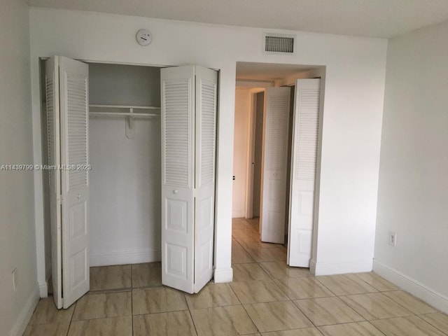 unfurnished bedroom featuring light tile flooring