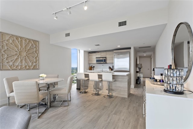 dining area with track lighting and light hardwood / wood-style floors