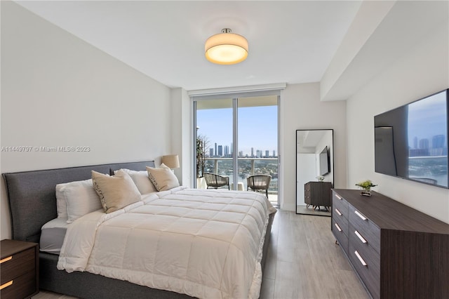 bedroom featuring access to exterior and light wood-type flooring