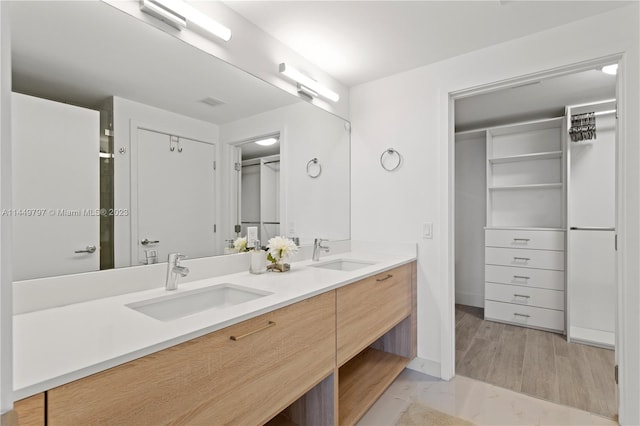 bathroom with double sink, vanity with extensive cabinet space, and tile flooring