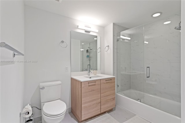 full bathroom featuring oversized vanity, toilet, tile floors, and shower / bath combination with glass door