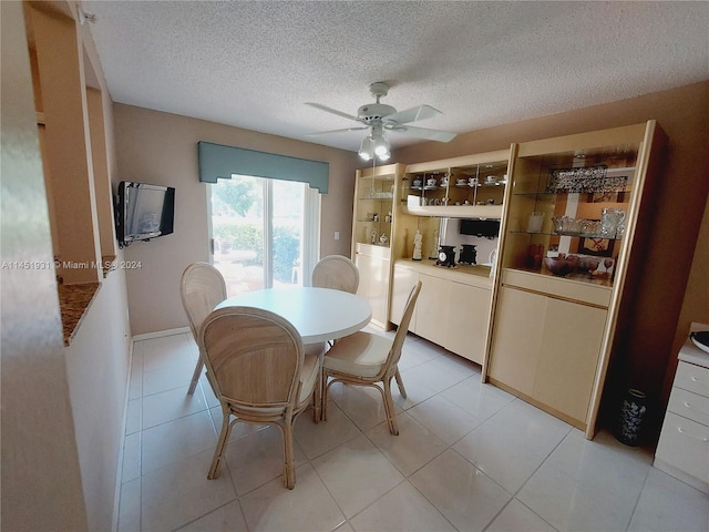 tiled dining area featuring ceiling fan and a textured ceiling