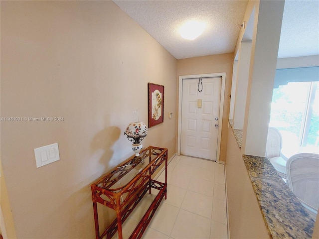 foyer entrance with tile floors and a textured ceiling