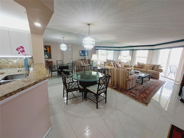 tiled dining room with sink, a textured ceiling, and a chandelier