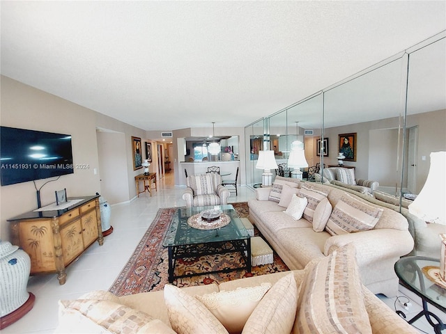 tiled living room featuring a textured ceiling and ceiling fan