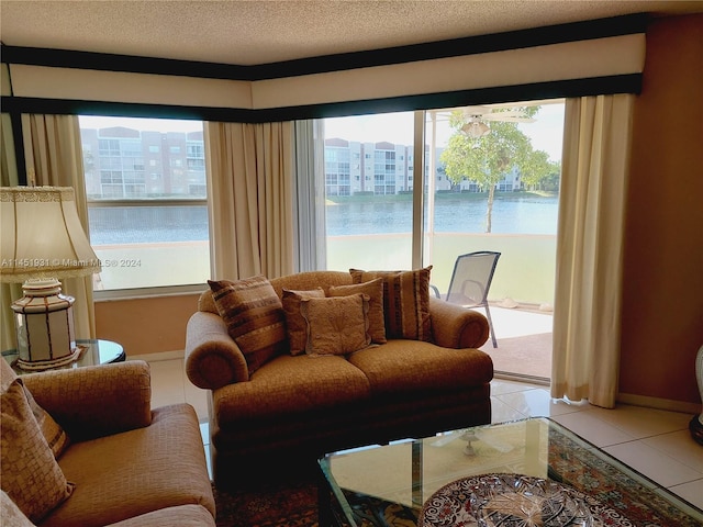 tiled living room with a water view and a textured ceiling