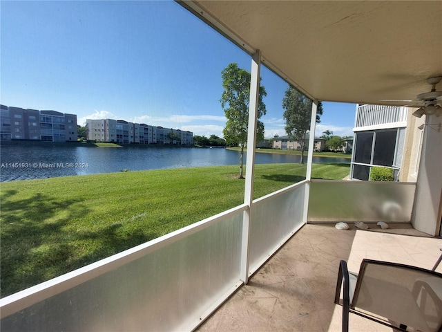 unfurnished sunroom with ceiling fan and a water view