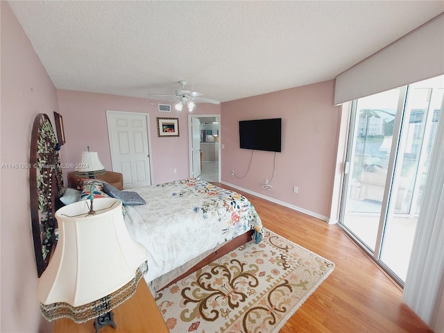 bedroom with access to outside, a textured ceiling, ceiling fan, and light hardwood / wood-style flooring