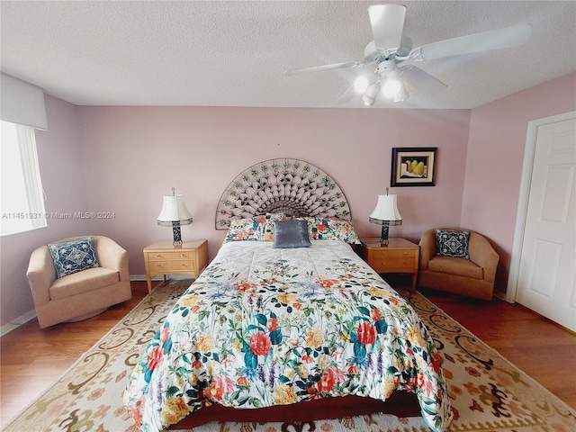 bedroom featuring wood-type flooring, ceiling fan, and a textured ceiling