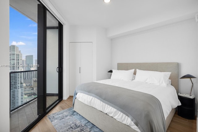 bedroom featuring a closet, floor to ceiling windows, and light hardwood / wood-style flooring