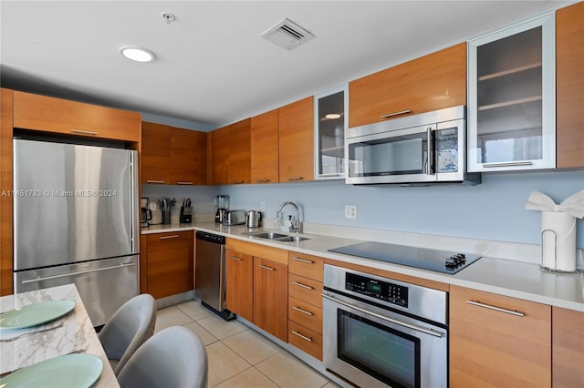 kitchen featuring stainless steel appliances, light tile patterned flooring, and sink