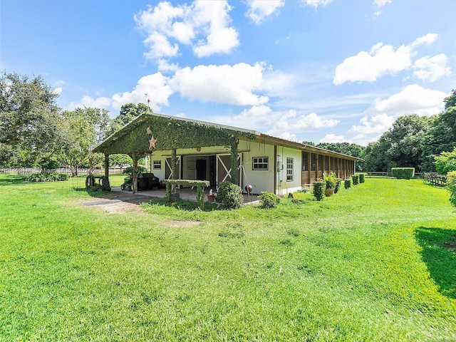 rear view of house with a lawn and a patio