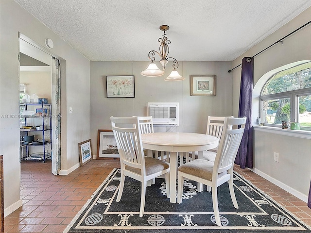 dining area with a textured ceiling and a chandelier