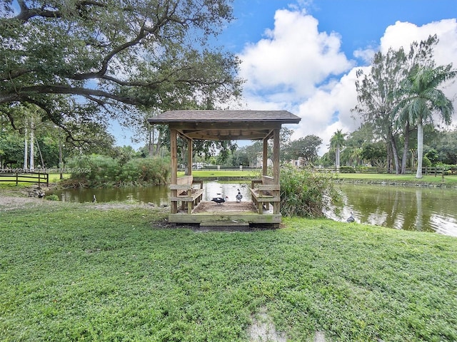 dock area with a yard and a water view