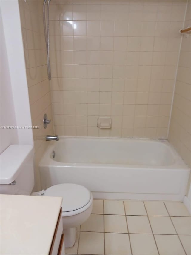 full bathroom featuring tile floors, toilet, vanity, and tiled shower / bath