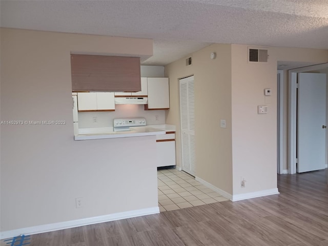 kitchen featuring a textured ceiling, light hardwood / wood-style floors, range, and white cabinetry