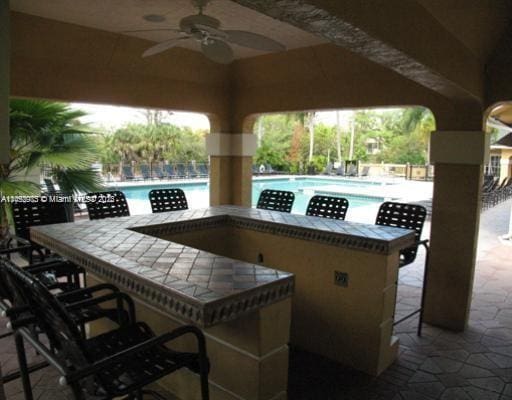 view of terrace featuring ceiling fan and a community pool