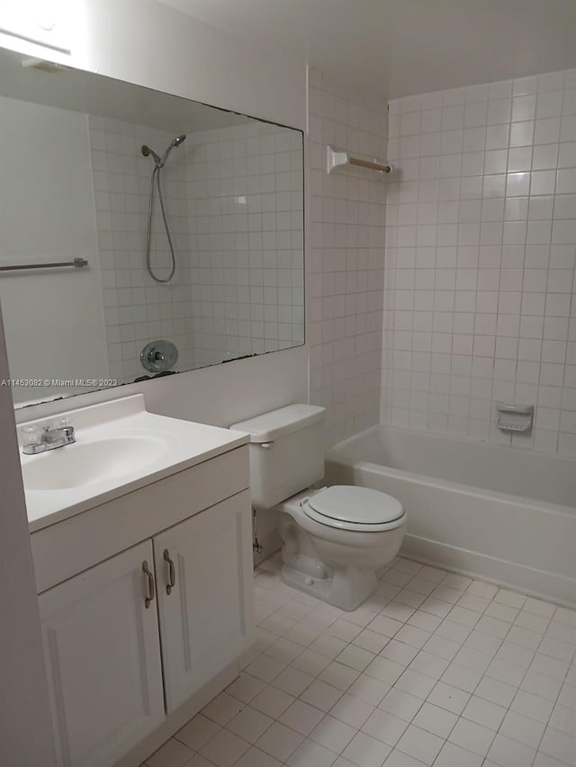 full bathroom with tiled shower / bath combo, toilet, tile floors, and large vanity