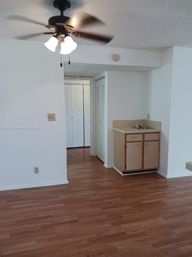 empty room featuring a textured ceiling, ceiling fan, and wood-type flooring