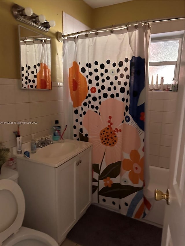 bathroom featuring vanity, toilet, and tile walls