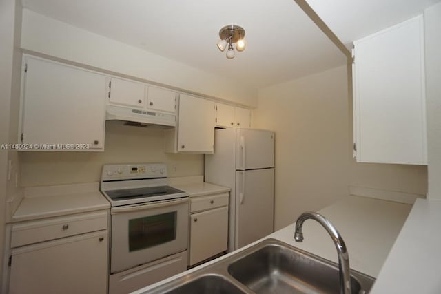 kitchen with white appliances, white cabinets, and sink