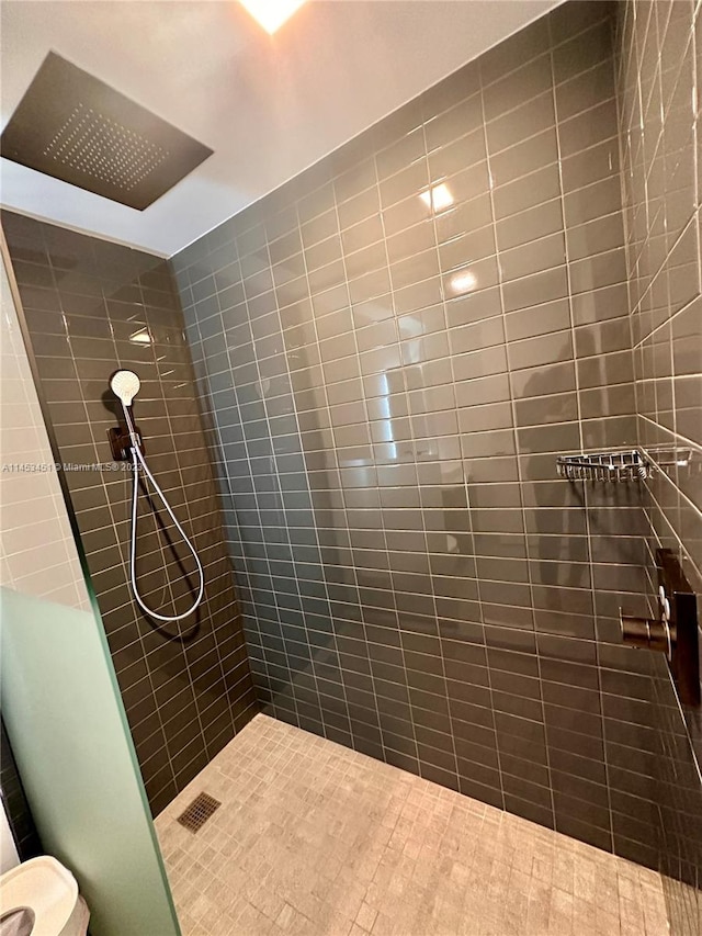 bathroom with toilet and a tile shower