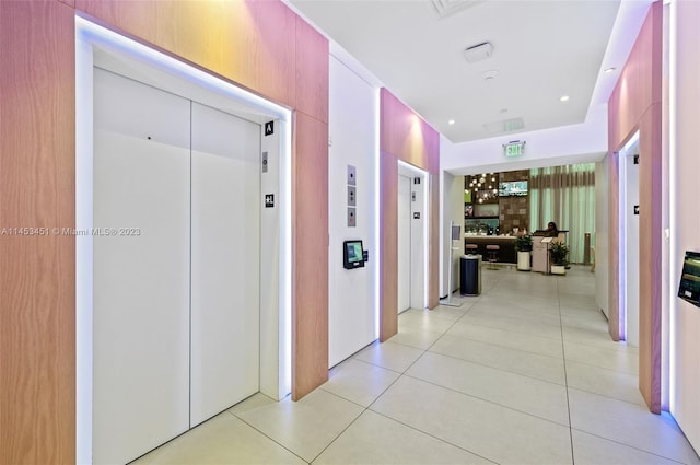 hallway with light tile floors and elevator