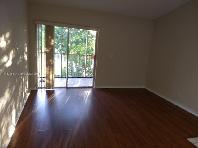 unfurnished room with dark wood-type flooring