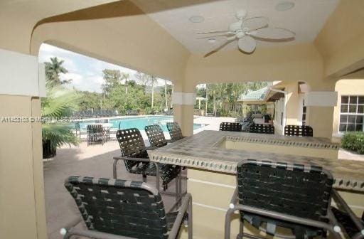 view of patio with a bar and ceiling fan