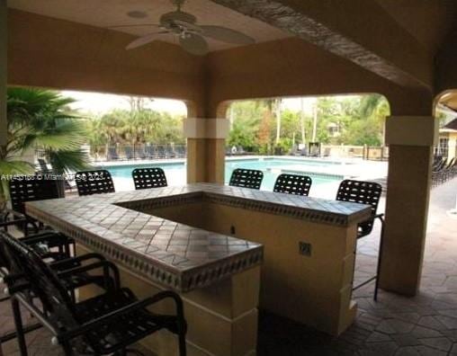 view of patio featuring ceiling fan and a community pool