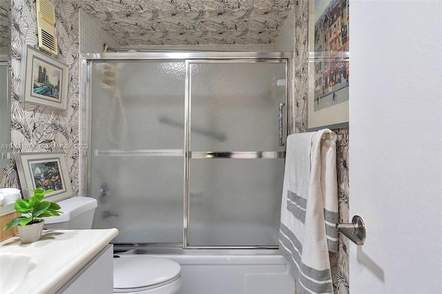 full bathroom featuring vanity, bath / shower combo with glass door, and toilet