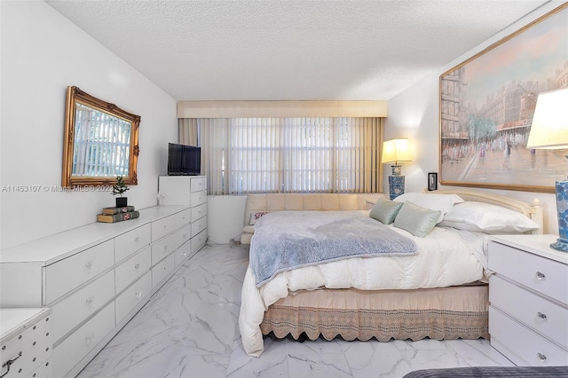 bedroom with light tile floors and a textured ceiling