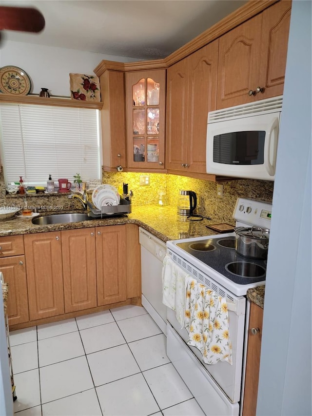 kitchen with white appliances, sink, light tile floors, light stone counters, and tasteful backsplash