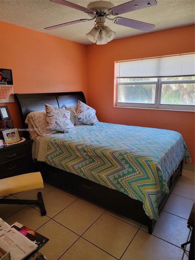 bedroom featuring a textured ceiling, ceiling fan, and tile flooring