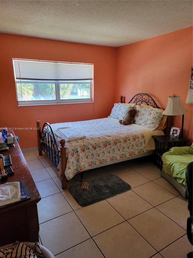 bedroom featuring a textured ceiling and light tile floors