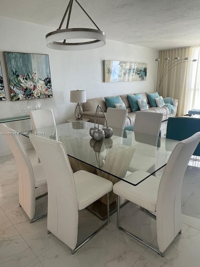 tiled dining room with an inviting chandelier