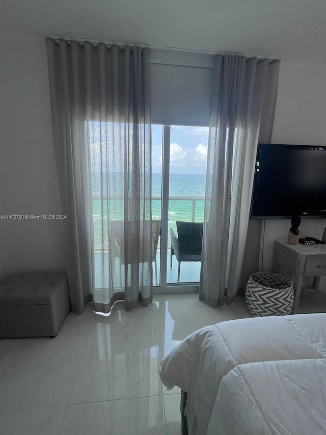 bedroom featuring a water view and light tile floors