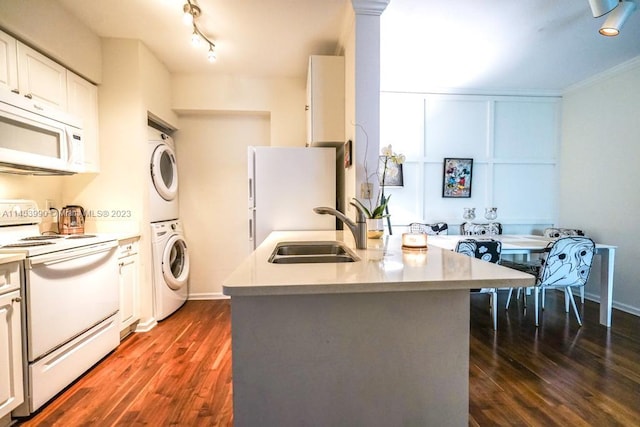 kitchen featuring dark hardwood / wood-style floors, white appliances, sink, track lighting, and white cabinetry