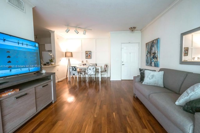 living room featuring track lighting, crown molding, and dark hardwood / wood-style flooring